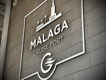 Sign for Malaga Cruise Port on a building wall.