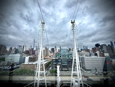 City skyline viewed through architectural structures under a cloudy sky.