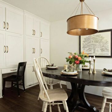 Elegant dining room with dark table and white chairs.