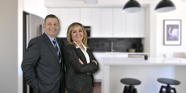 Two professionals standing smiling in a modern kitchen.