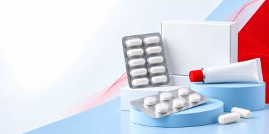 Medication tablets and cream tubes arranged on blue and white surfaces.