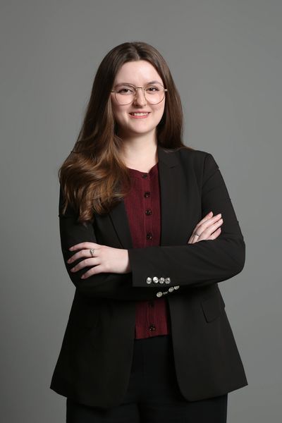 Young woman with glasses smiling at the camera.