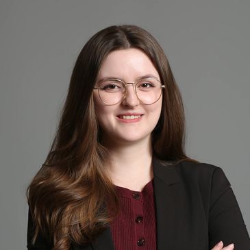 Young woman with glasses smiling.