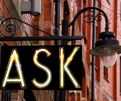 An illuminated sign displaying the word ASK.