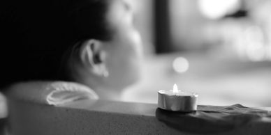 Woman practicing self-care by relaxing in a bath tub.