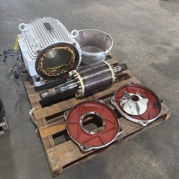 Disassembled electric motor parts on a wooden pallet.