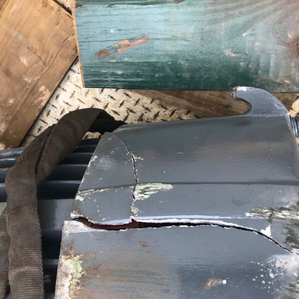 Cracked and damaged metal surface on equipment.
