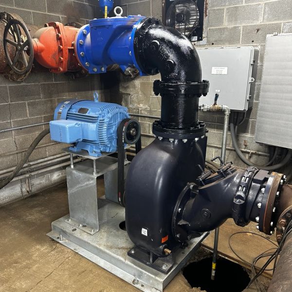 Industrial water pump system in a mechanical room.