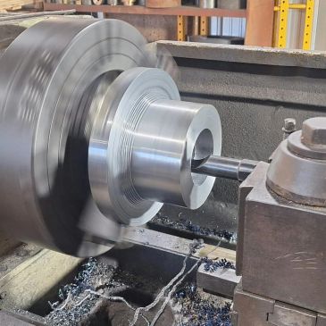 Metalworking lathe machining a metal part.