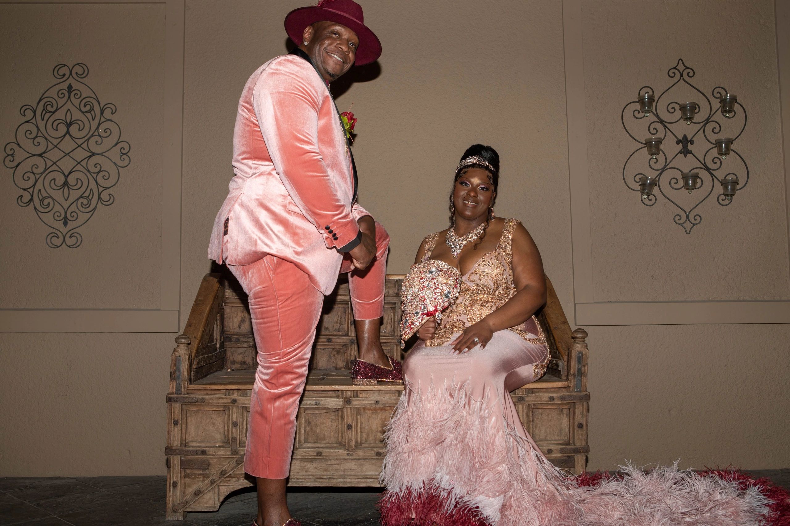 Couple dressed elegantly in coordinated pink and gold attire.