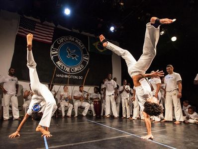 Mestre Jabá & a Kid from Capoeira Malês North Seattle performing acrobatic movements during a roda.