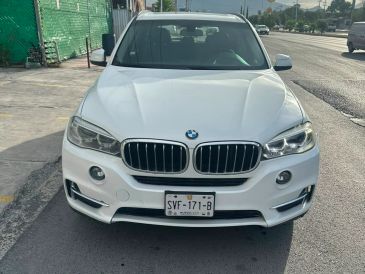 Frontal de un BMW blanco estacionado en la calle.