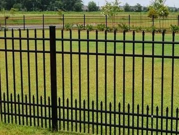 Black aluminum metal fence for dogs enclosing a green grassy area with warranty badge.
