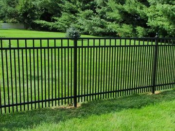 Black aluminum metal fence with a 3-year warranty badge in a grassy backyard.