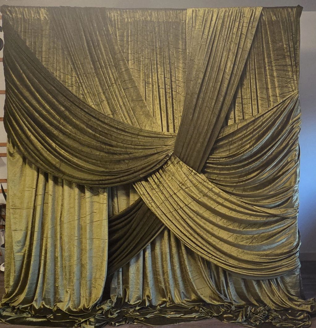 Luxurious golden velvet curtains draped in an intricate overlapping design.