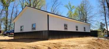 Newly built white and black barn building.