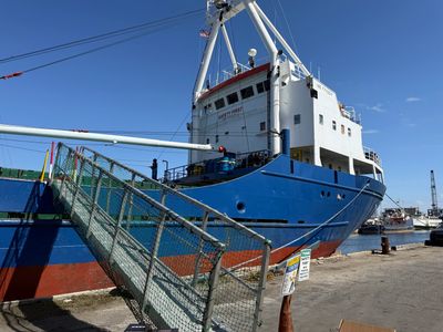 Blue cargo ship moored at a pier