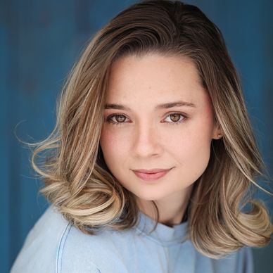 Portrait of a young woman with light brown hair and a soft smile.