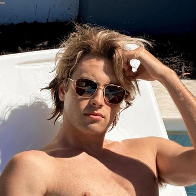 Young man relaxing outdoors in sunglasses.
