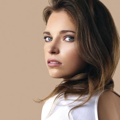 Close-up portrait of a woman with blue eyes and brown hair.