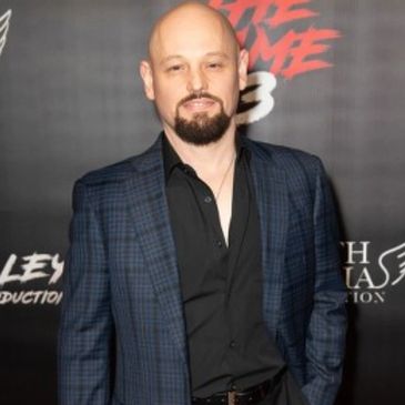 Man in a checkered blazer at an event.