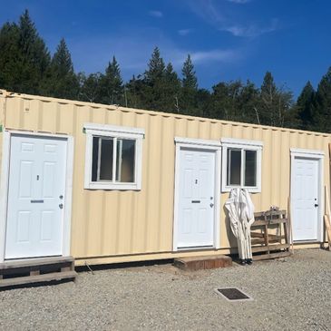 A container converted into a building with doors and windows.