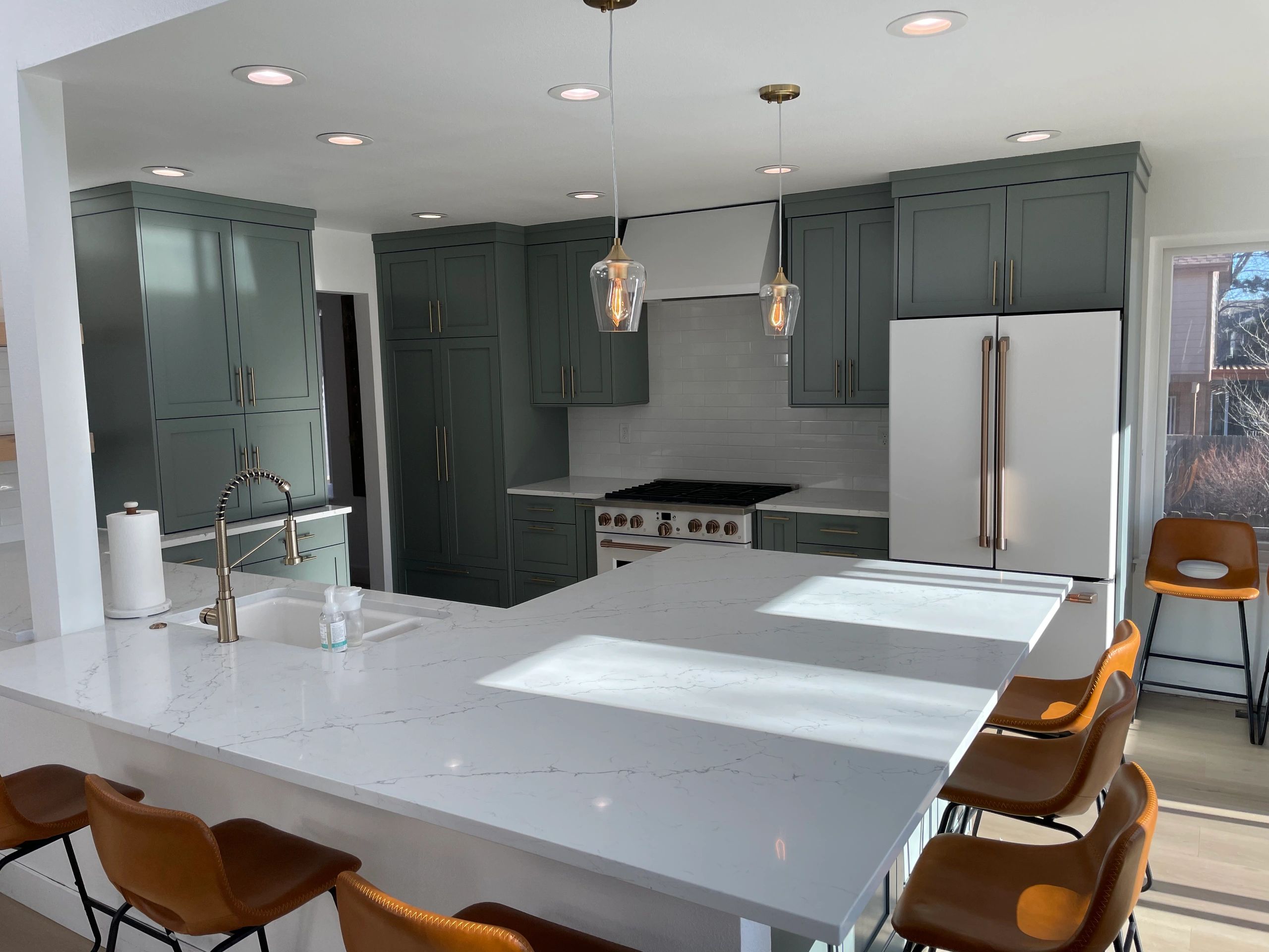 Green shaker kitchen in a Englewood home with white appliances, inviting a transitional design.