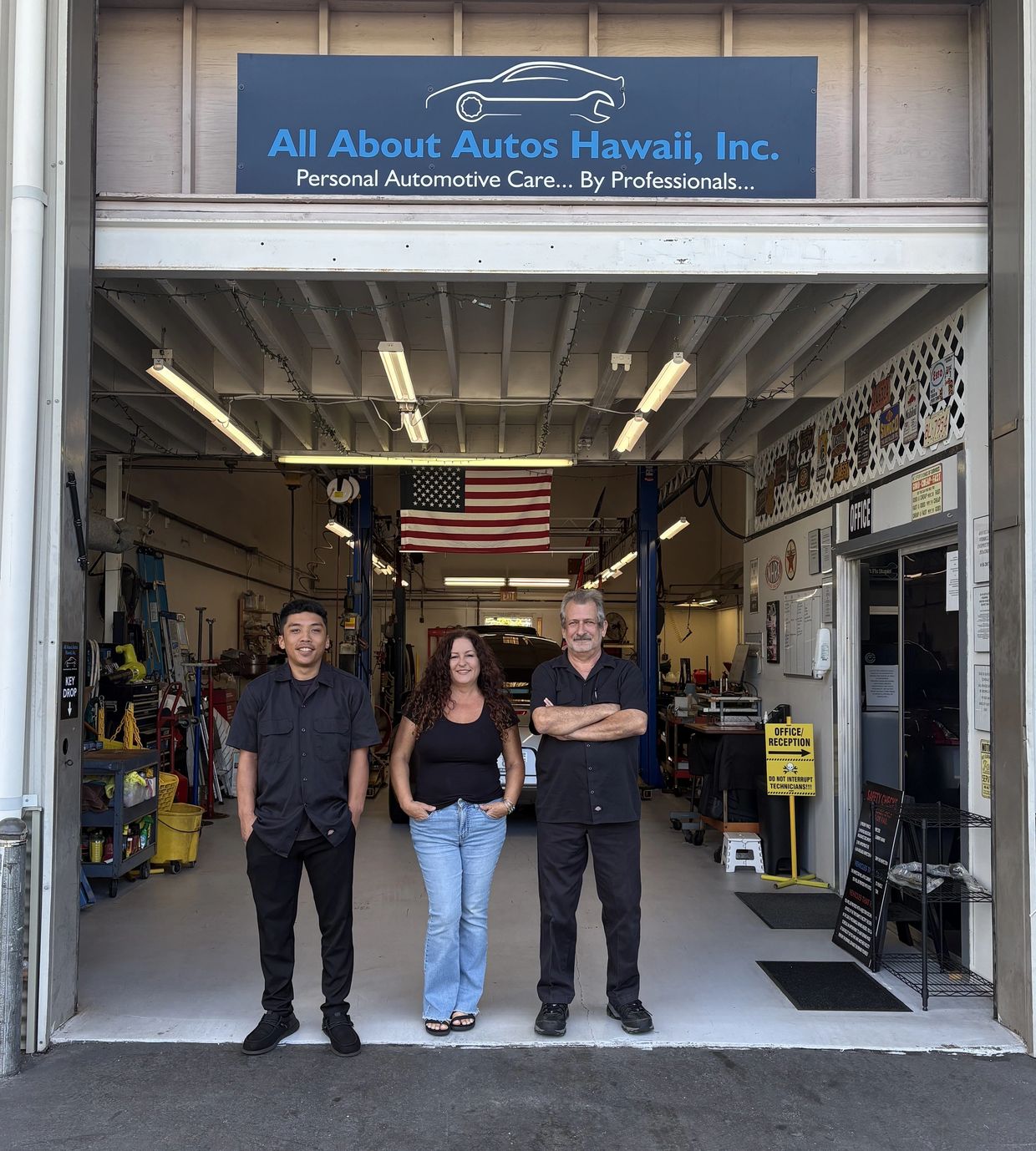 Three employees standing outside an auto repair shop in Hawaii.