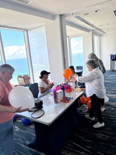 People preparing balloons at a seaside venue.