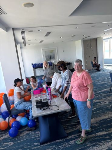 Group of women with balloons and crafts in a room.