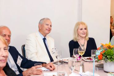 A group of people sitting at a table during a formal event.