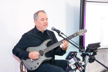 Man playing electric guitar and singing into a microphone.