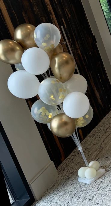 Elegant cluster of gold, white, and confetti balloons.
