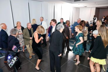 A group of people dancing and socializing at an indoor event.