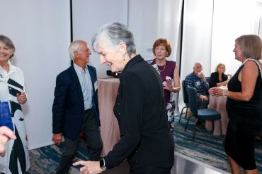 Seniors socializing and dancing at a lively indoor event.