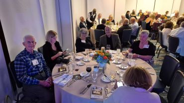 A group of people sitting around a dinner table at an event.