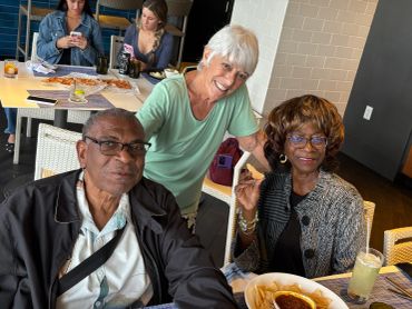 Three people enjoying a meal together at a restaurant.