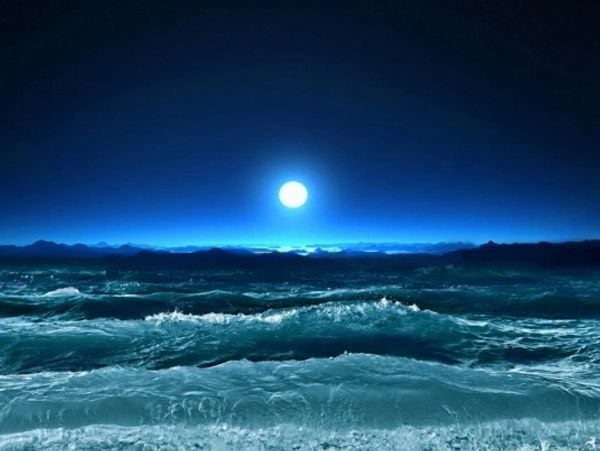 A tranquil ocean scene at night with rolling waves and a bright full moon 