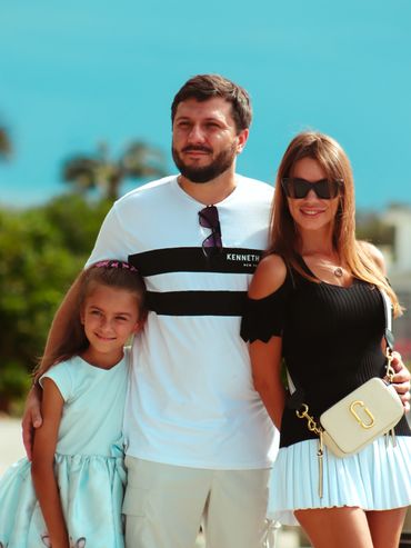 Family portrait with vibrant blue sky.