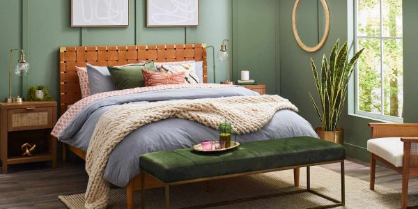 Cozy bedroom with green walls and wooden furniture.