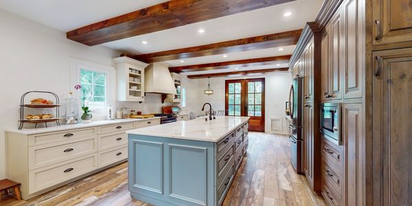 Spacious kitchen with wooden beams and a large island.