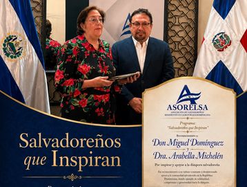Dos personas reciben un reconocimiento en un evento salvadoreño.