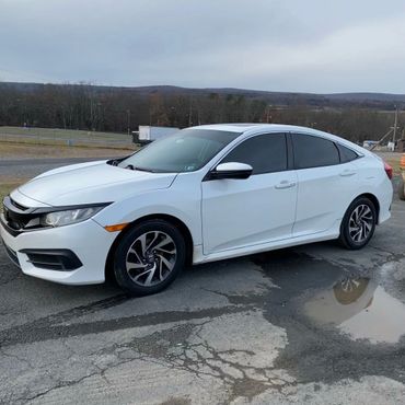 a white car parked in front of a warehouse