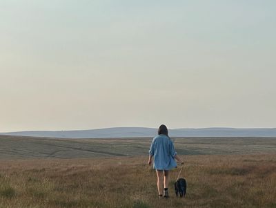 woman walking on dartmoor alone with a dog