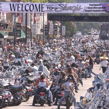 Crowded street filled with motorcycles and people at Sturgis Motorcycle Rally.