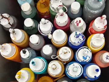 Assorted colorful paint bottles arranged closely together.