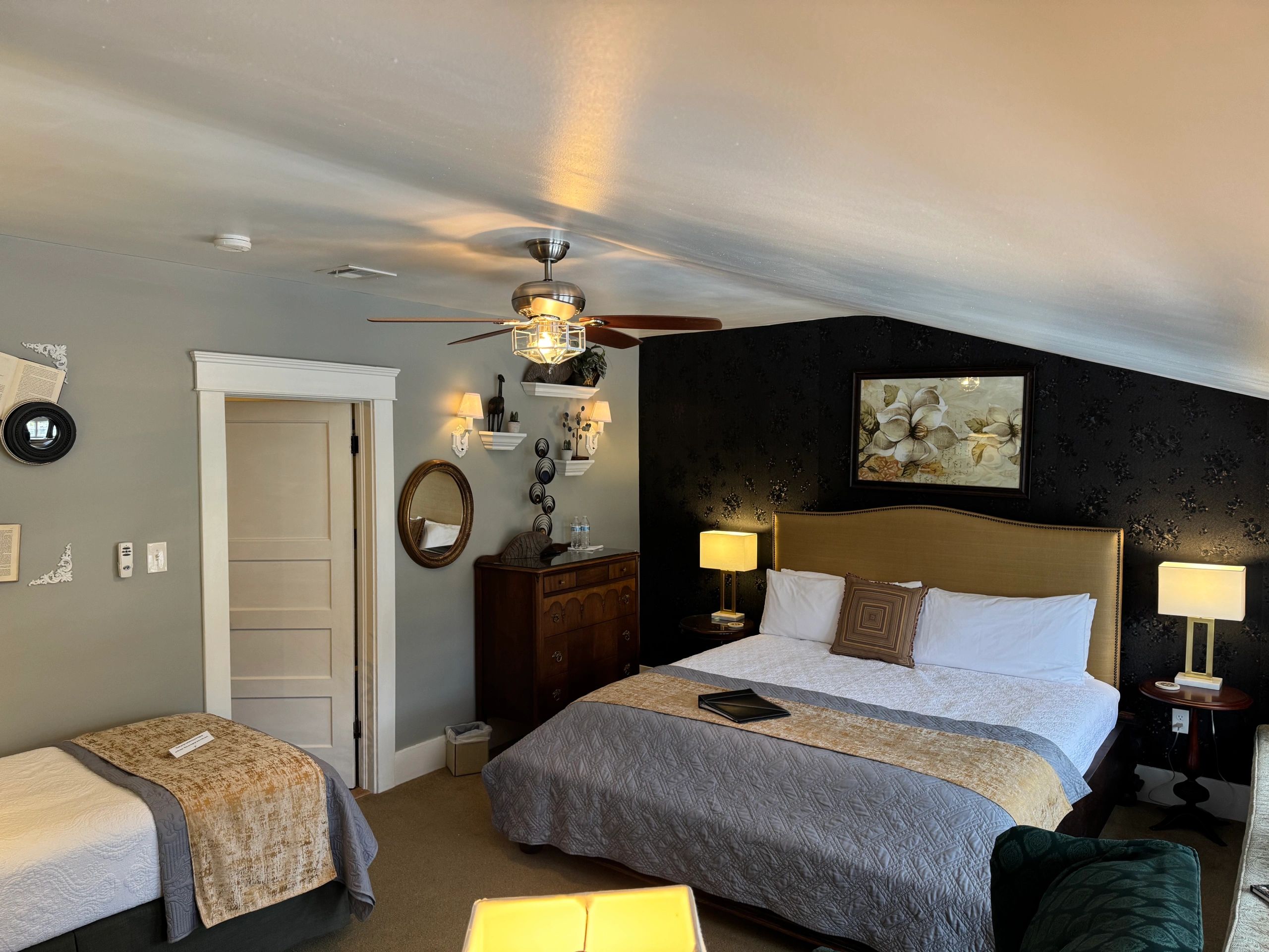 A hotel room with two beds, a dresser, and a mirror