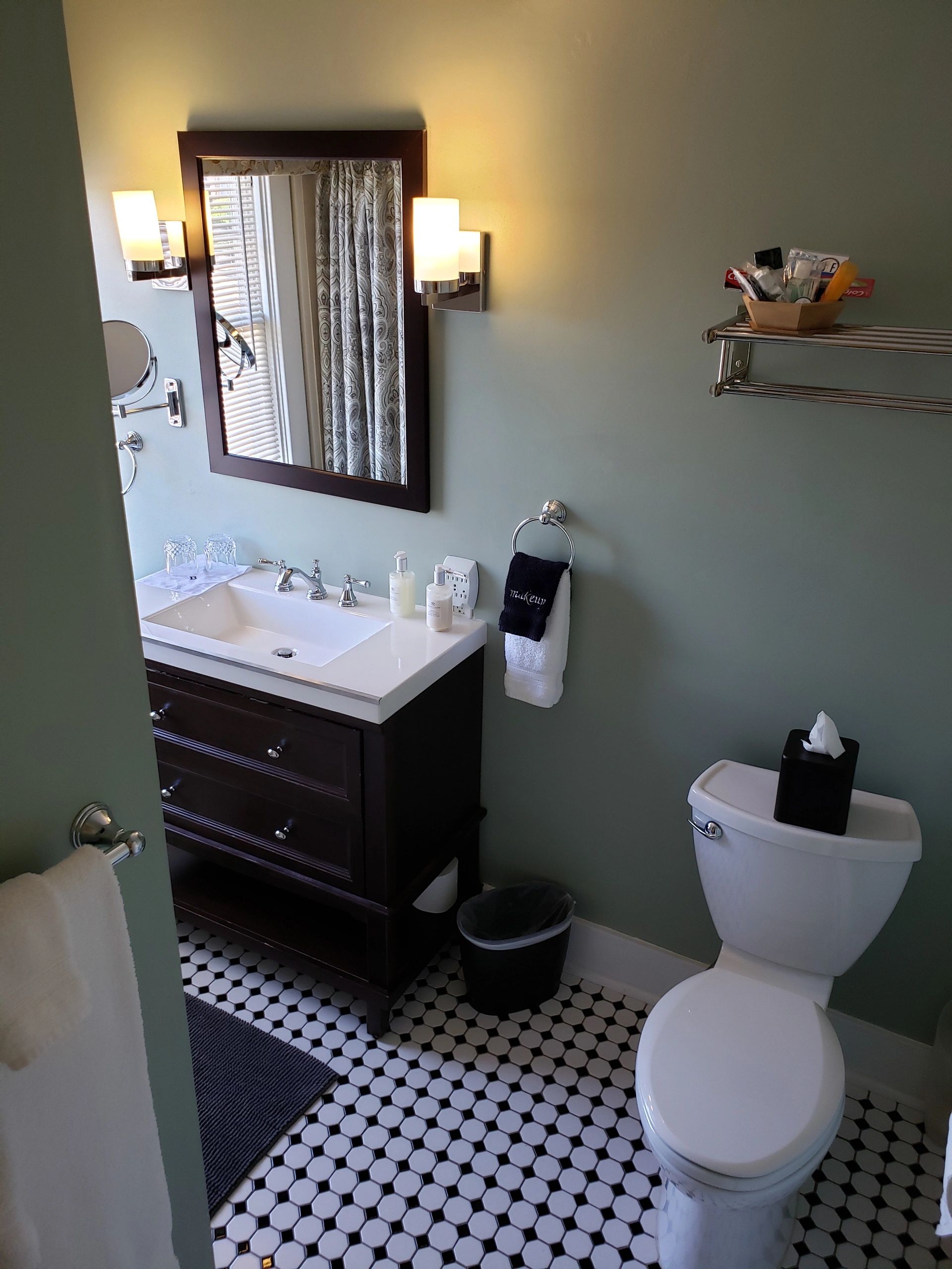 A bathroom with a toilet, sink, and mirror