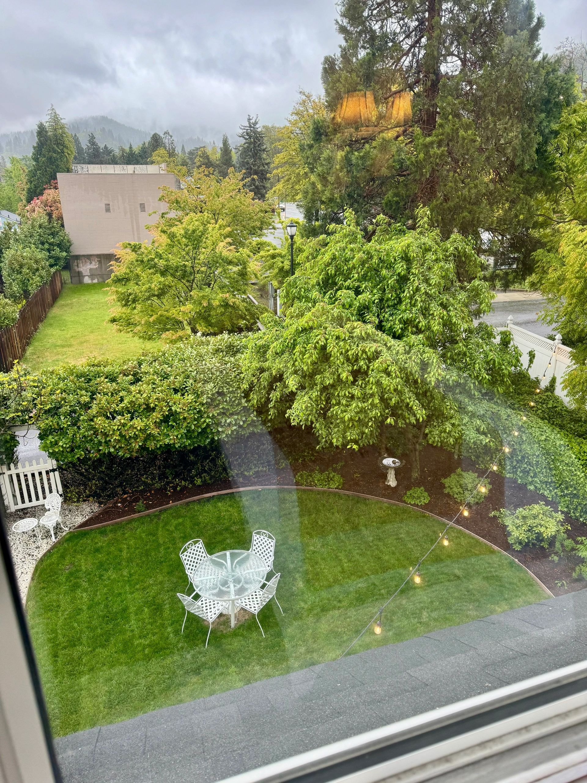 a small grassy area with white furniture and trees