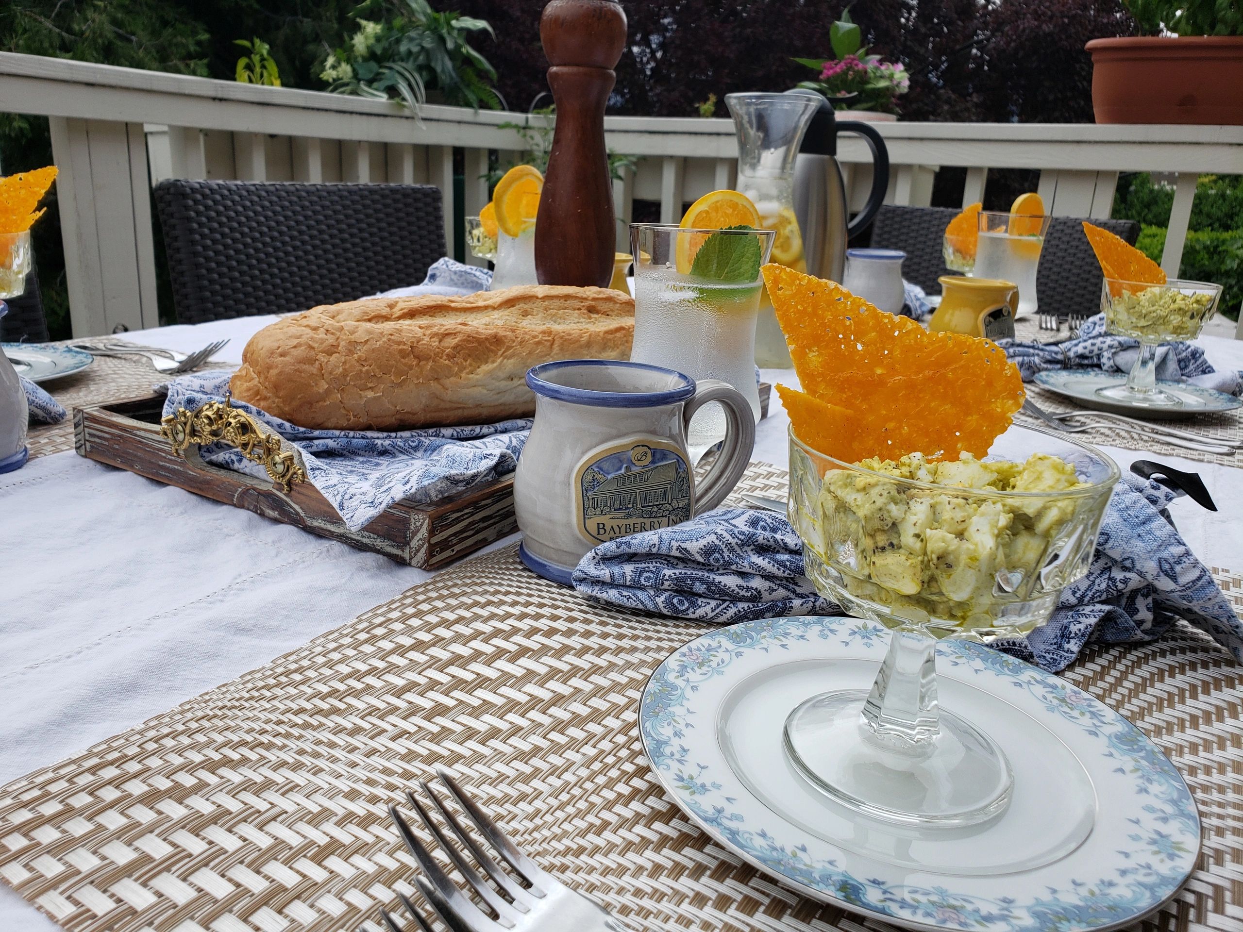 A table set for breakfast on an outdoor patio with food and drinks.